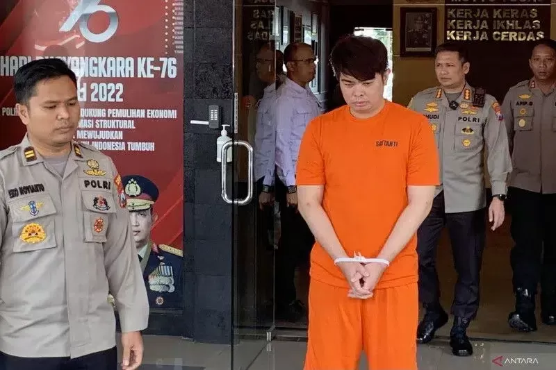 Tersangka kasus investasi robot trading ATG Raymond Enovan (berbaju oranye) pada saat dirilis di Polresta Malang Kota, Jawa Timur, Kamis (16/3/2023). foto: antara 