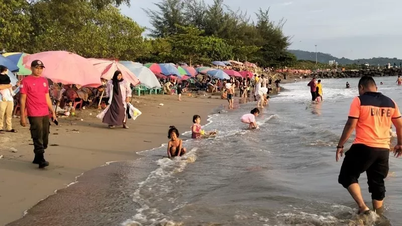 Pengunjung berenang di kawasan objek wisata Pantai Padang saat libur Lebaran, Sabtu (21/3/2026). (Foto: BPBD Padang)