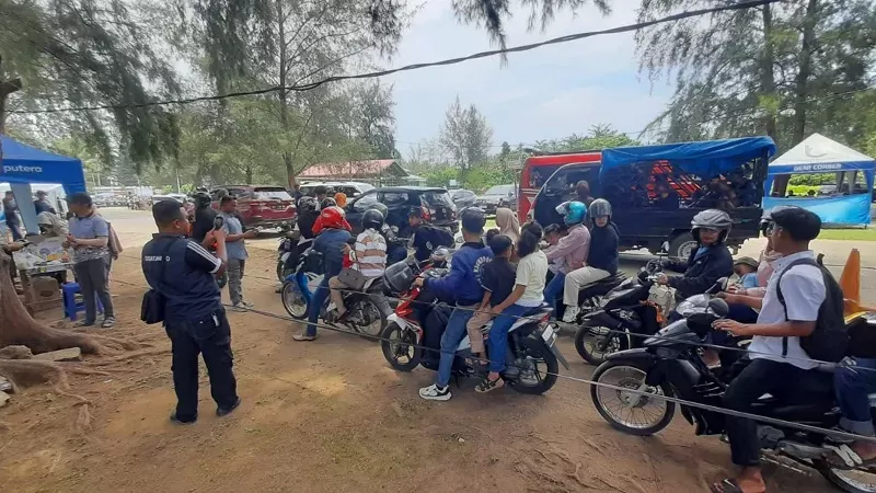 Wisatawan saat memasuki kawasan objek wisata Pantai Air Manis. (Foto: Kominfo Padang)