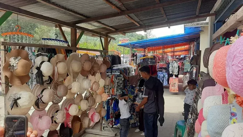 Wisatawan melihat produk UMKM yang dijual di kawasan objek wisata Pantai Air Manis. (Foto: Kominfo Padang)