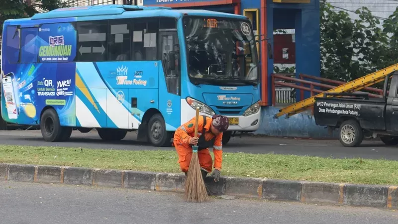 Petugas kebersihan tengah membersihkan area taman jalan di Kota Padang. (Foto: Kominfo Padang)