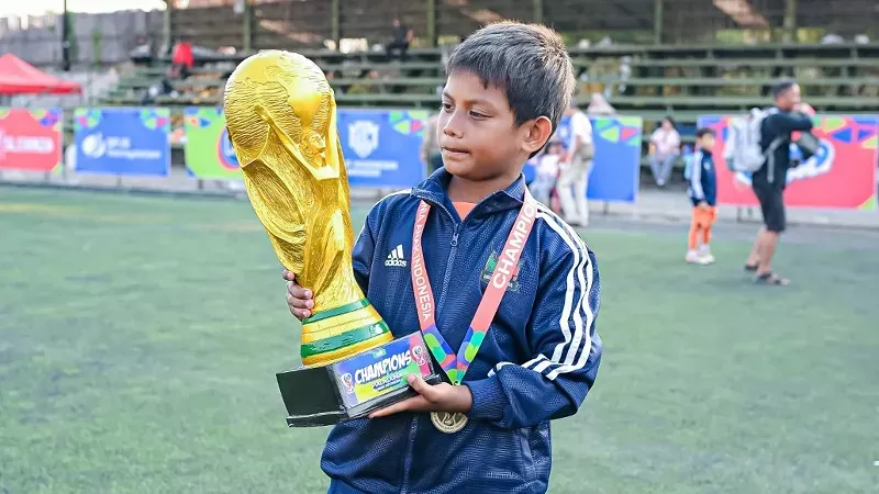 Akhsyal Duenino Irwan yang akrab disapa Duen memegang trofi Piala Dunia Anak Indonesia U9 2026. (Foto: Istimewa)
