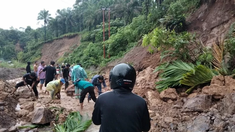 Alat berat dikerahkan untuk menangani material longsor yang menutup akses jalan di sejumlah titik di Kabupaten Agam, Jumat (25/9/2026). (Dok. Pusdalops PB)