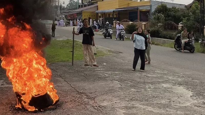 Emak-emak protes pembakaran ban saat aksi demo di depan Rutan Padang di tengah kondisi kabut asap karhutla. (Foto: flowmedia.id)