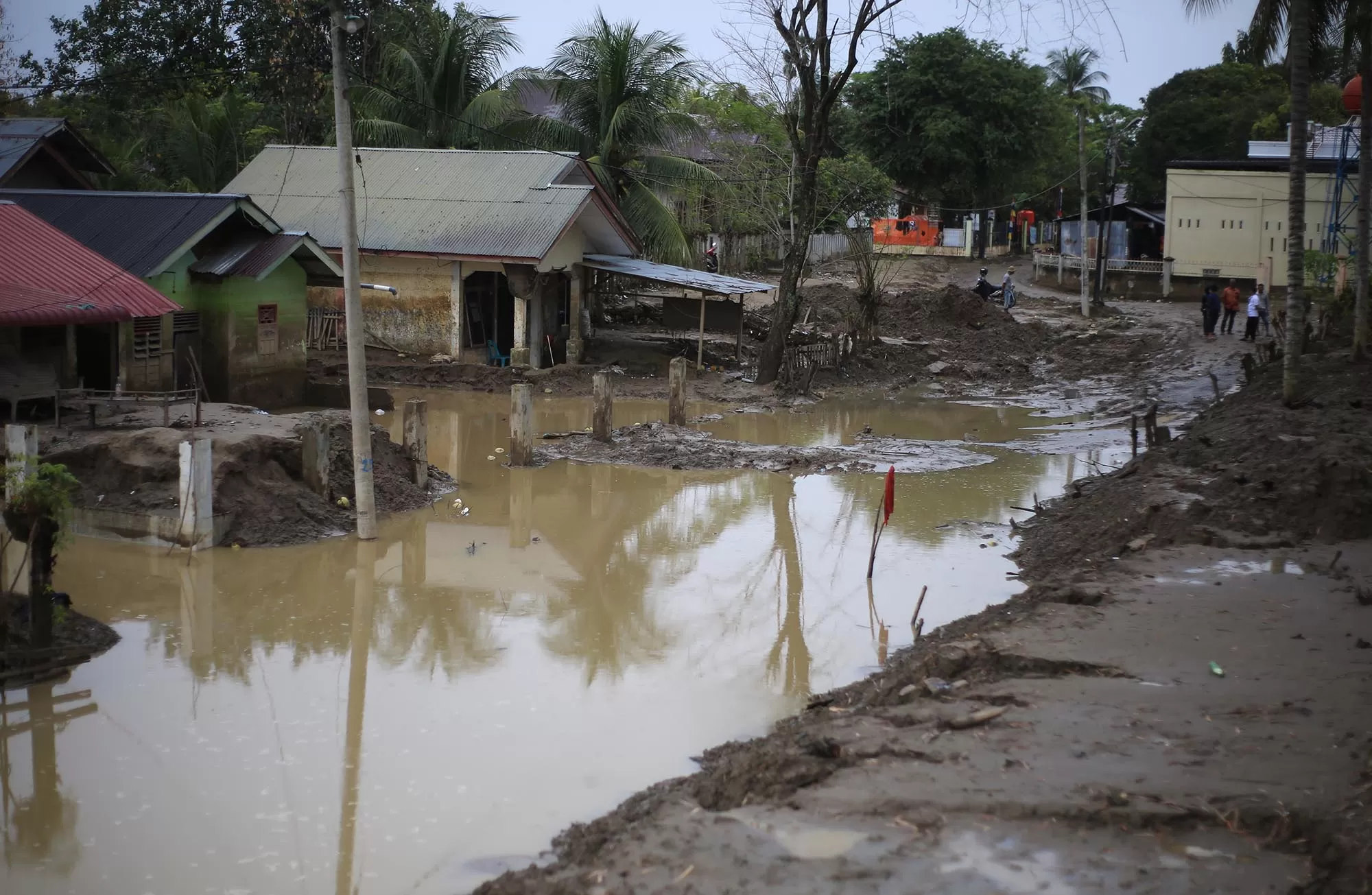 Warga menyaksikan genangan air dan lumpur di sejumlah rumah yang terdampak bencana banjir di desa Meunasah Raya, kabupaten Pidie Jaya, Aceh, Selasa (17/2/2026).  Hampir tiga bulan pasca bencana banjir, rumah warga  di pedesaan masih tertimbun lumpur dan selain genangan air. Aentenews Foto/Ampelsa.