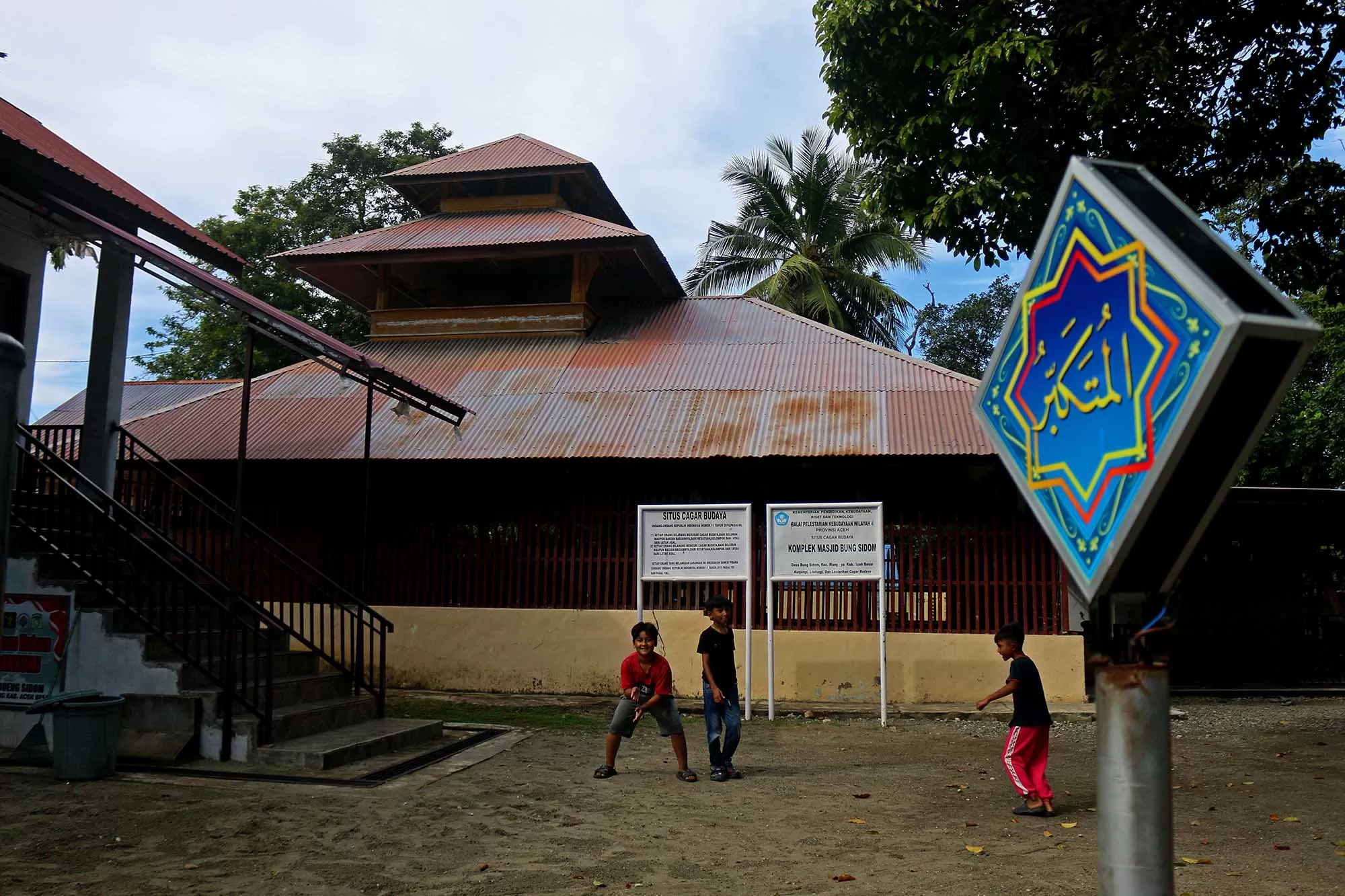 Anak anak bermain di komplek situs cagar budaya Masjid Bung Sidom, di Desa Bung Sidom, Keceamatan Blang Bintang., kabupaten Aceh Besar,  Selasa (24/2/2026). Masjid bersejarah yang terbuat dari  kontruksinya kayu dan tetap terawat hingga saat ini dibangun tahun 1250 H atau 1834 M pada masa pemerintahan Sultan Alaidin Muhammad Daud Syah I (1830- 1838 M) setelah  sempat dibakar  pada masa penjajahan Belanda. Aentenews Foto/Ampelsa.