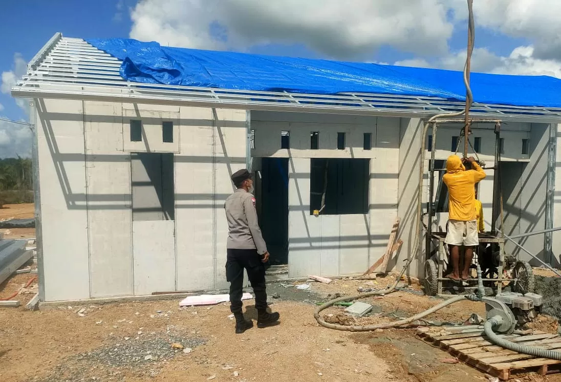 Personil Polri mengawasi pekerja menyelesaikan pembangunan hunian tetap (Huntap) di kabupaten Aceh Tamiang, Minggu  (1/3/2026). . Aentenews/Foto Humas Polda Aceh