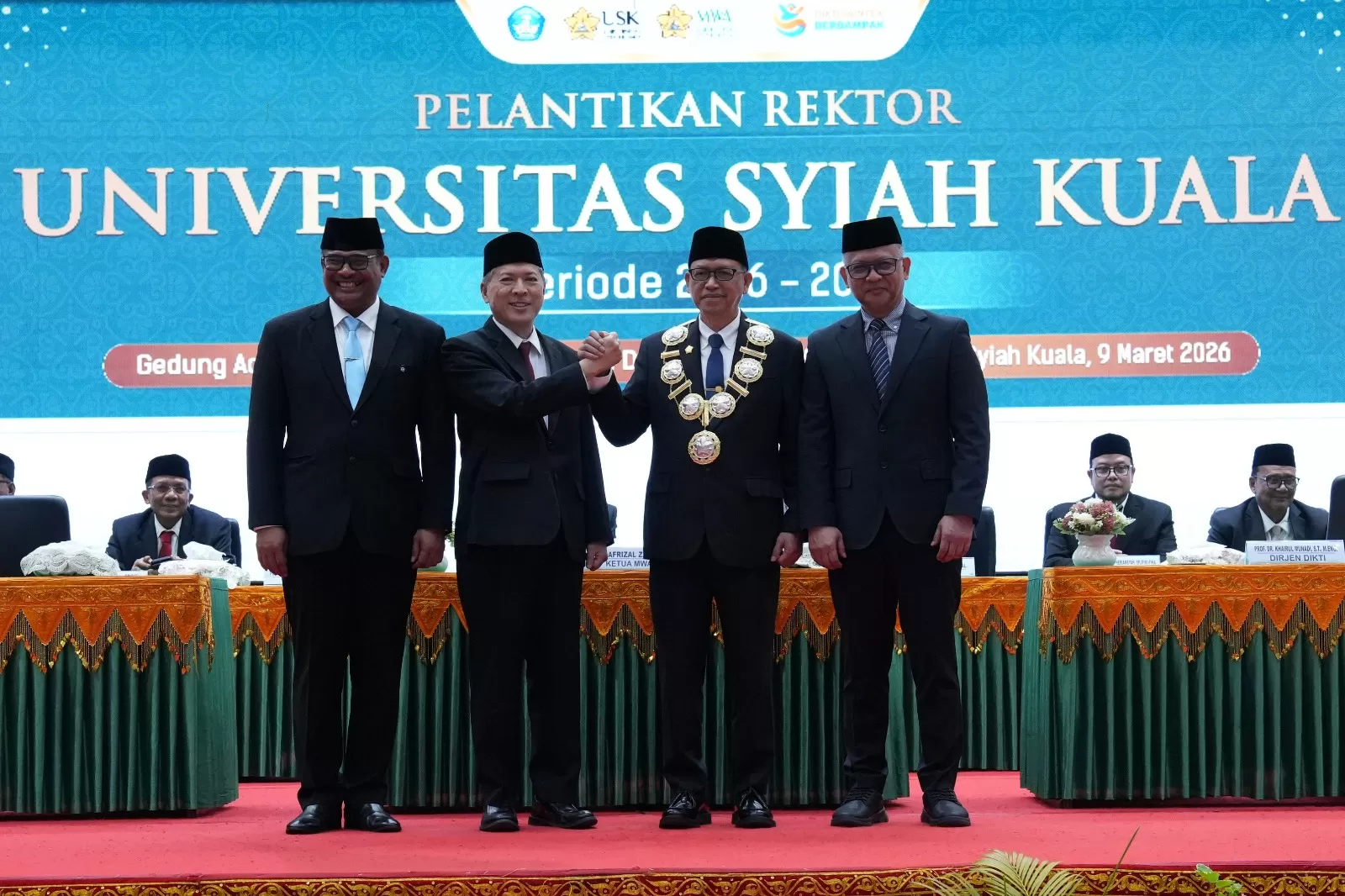Rekrot USK , Prof Mirza Tabrani (kedua kanan) periode 2026 – 2031 berjabat tangan dengan rektor sebelumnya Prof Marwan (kedua kiri) seusai pelantikan dan pengambilaan sumpah di Gedung AAC Dayan Dawood, di Banda Aceh  Senin (9/3/2026) Foto humas USK. 