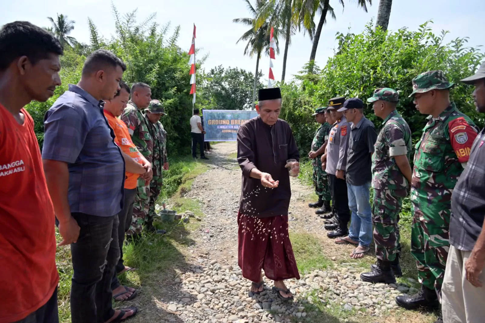 Tokoh adat melakukan tradisi peusijuk saat peletakan batu pertama pembangunan jembatan aramco di Pidie. Foto Penrem Lilawangsa