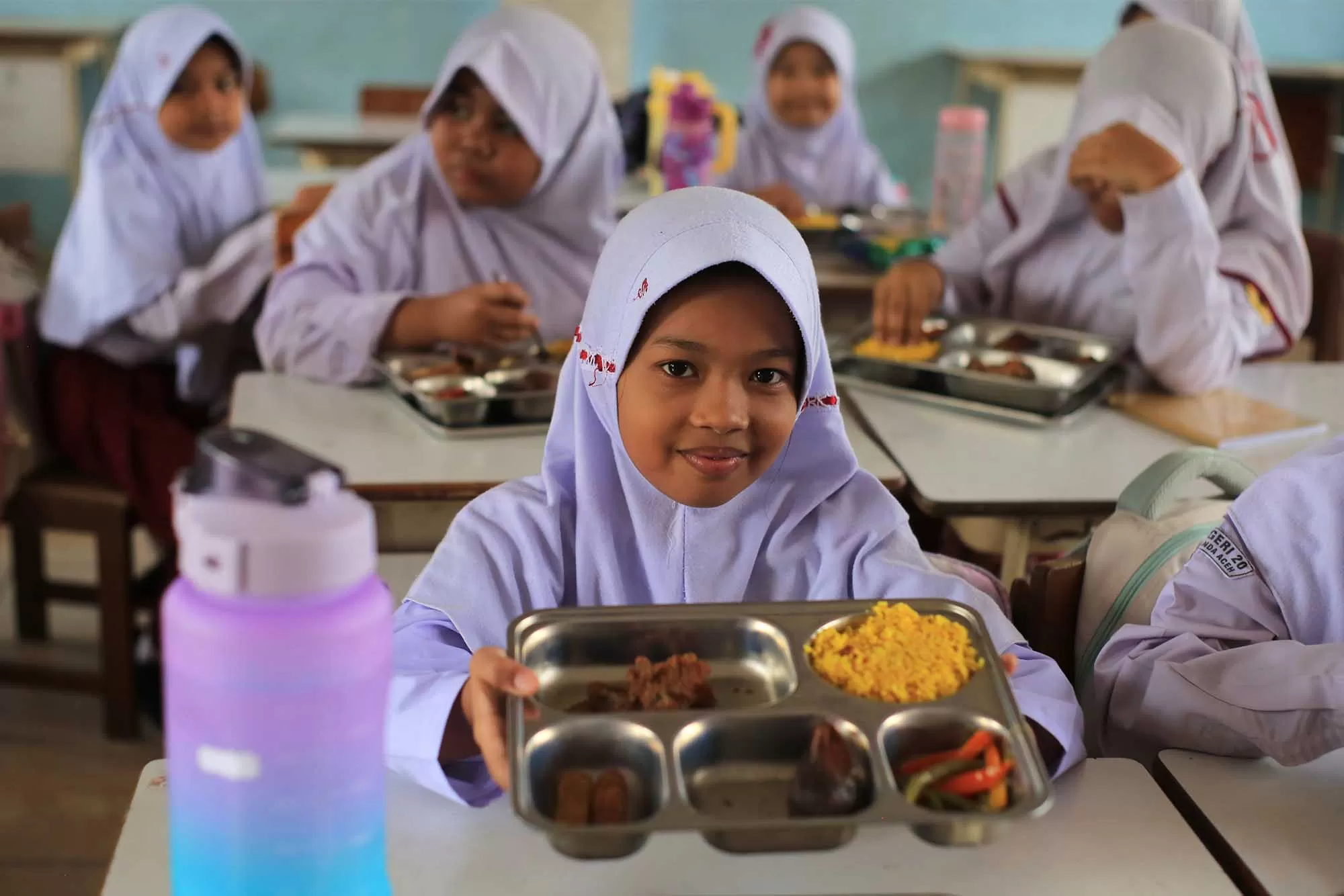 Sejumlah siswa bersiap menyantap  Makanan Bergizi Gratis (MBG) pada hari pertama pascalebaran Idul Fitri di SDN 20 Banda Aceh, Selasa (31/3/2026).  Pascalibur Idul Fitri pemerintah fokus pada peningkatan kualitas MBG dan selain melakukan efisiensi anggaran dengan memangkas jumlah hari operasional  menjadi lima hari dari sebelumnya enam hari dalam sepekan. Aentenews Foto/Ampelsa.
