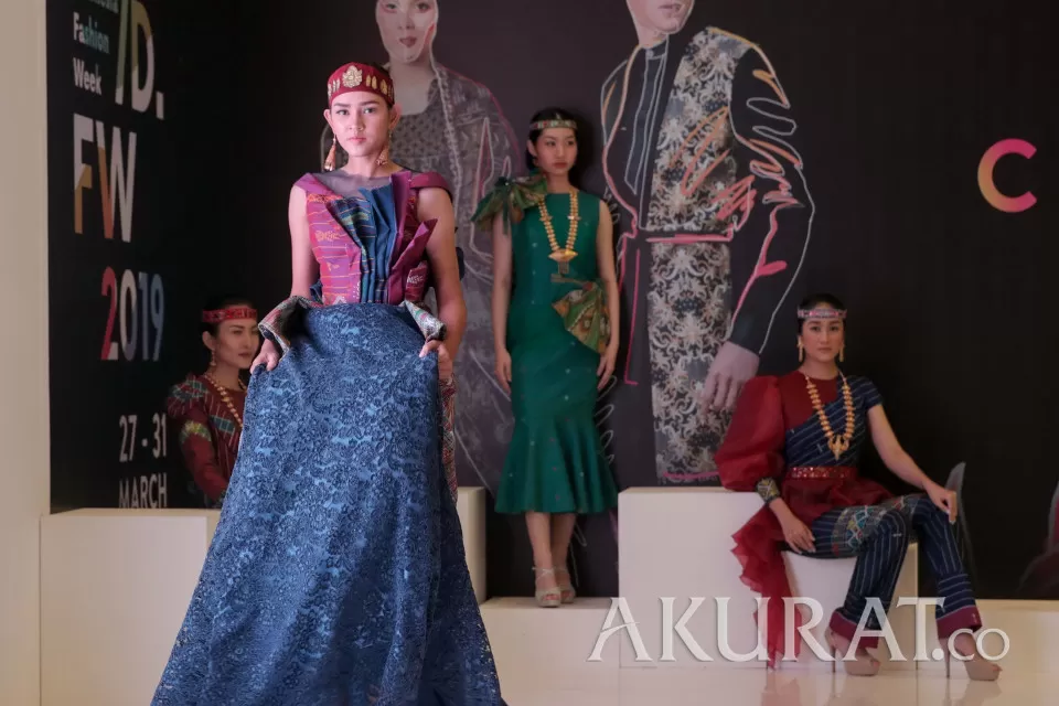 Model mengenakan busana karya dari desainer Dessi Simbolon dalam acara Indonesia Fashion Week 2019, di Jakarta Convention Center (JCC), Jakarta, Kamis (28/3/2019). Desainer Dessi Simbolon mengangkat keindahan kain tenun nusantara yaitu Ulos Sadum dari Tapanuli, Sumatera Barat.