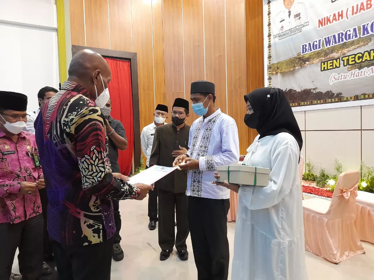 Wali Kota Jayapura Dr Benhur Tomi Mano, MM menyerahkan menyerahkan akta nikah bagi salah satu pasangan nikah massal di Aula Sian Soor Kantor Wali Kota Jayapura, Rabu (23/2). (Ayu/Cepos)