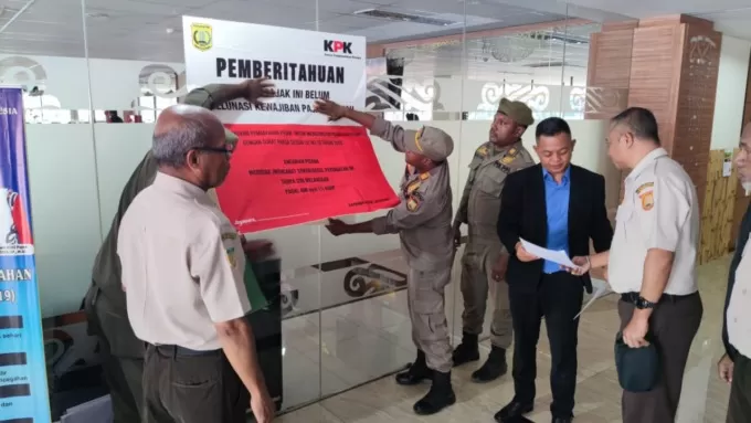 Petugas Satpol PP dan pegawai Bapenda Kota Jayapura, saat menyegel Wisma Atlet Mandala, Kota Jayapura, Selasa (27/6).  Robert Mboik/Cepos