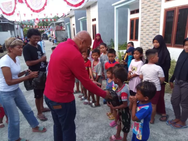 Tenaga Ahli Mensos RI Bidang Rehabilitasi Sosial, Dr. Benhur Tomi Mano, MM., saat menyerahkan hadiah lomba kepada anak-anak yang mengikuti lomba dalam rangka memperingati HUT ke-78 RI di Jalan Cempedak 1 RW 11 Kelurahan Koya Timur, Distrik Muara Tami, Rabu (16/8) sore. (Yonathan/Cepos)