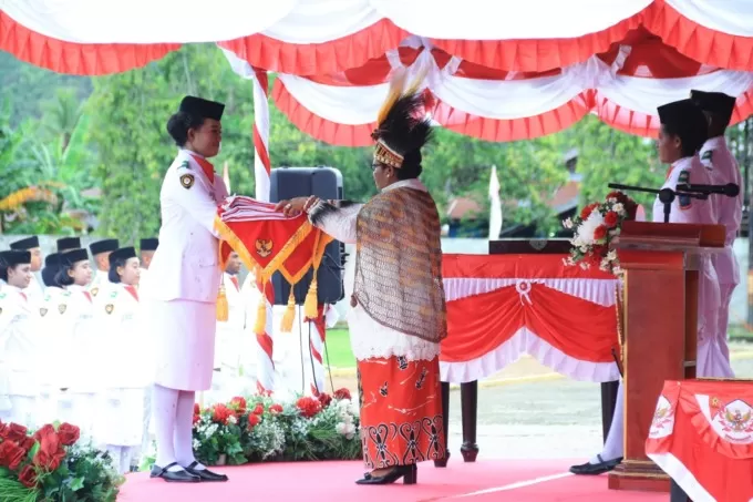 Pejabat Gubernur Provinsi Papua Tengah, Ribka Haluk menyerahkan bendera merah putih kepada anggota Parsibraka untuk dikibarkan pada upacaraperingatan HUT RI ke 78 di Nabire, Papua Tengah, ( Kamis 17/8). bendera berukuran 2x3 meter  ini dijahit oleh ibu Ribka Haluk sendiri. foto: Theresia/Cepos