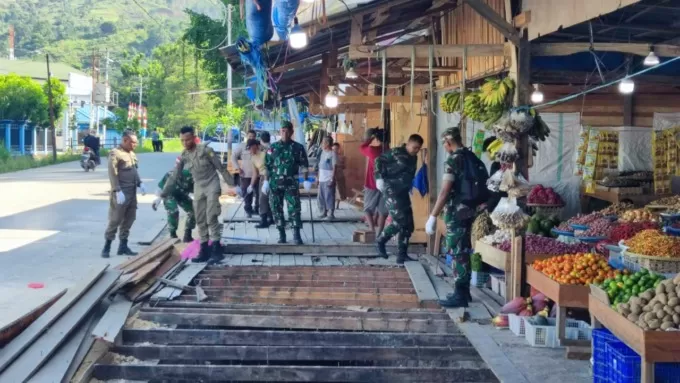 Petugas gabungan dari Pemkot Jayapura membongkar bagian jembatan dari lapak yang dibangun di sekitar jalan masuk pasar Youtefa, Rabu (6/9). (Robert Mboik Cepos)