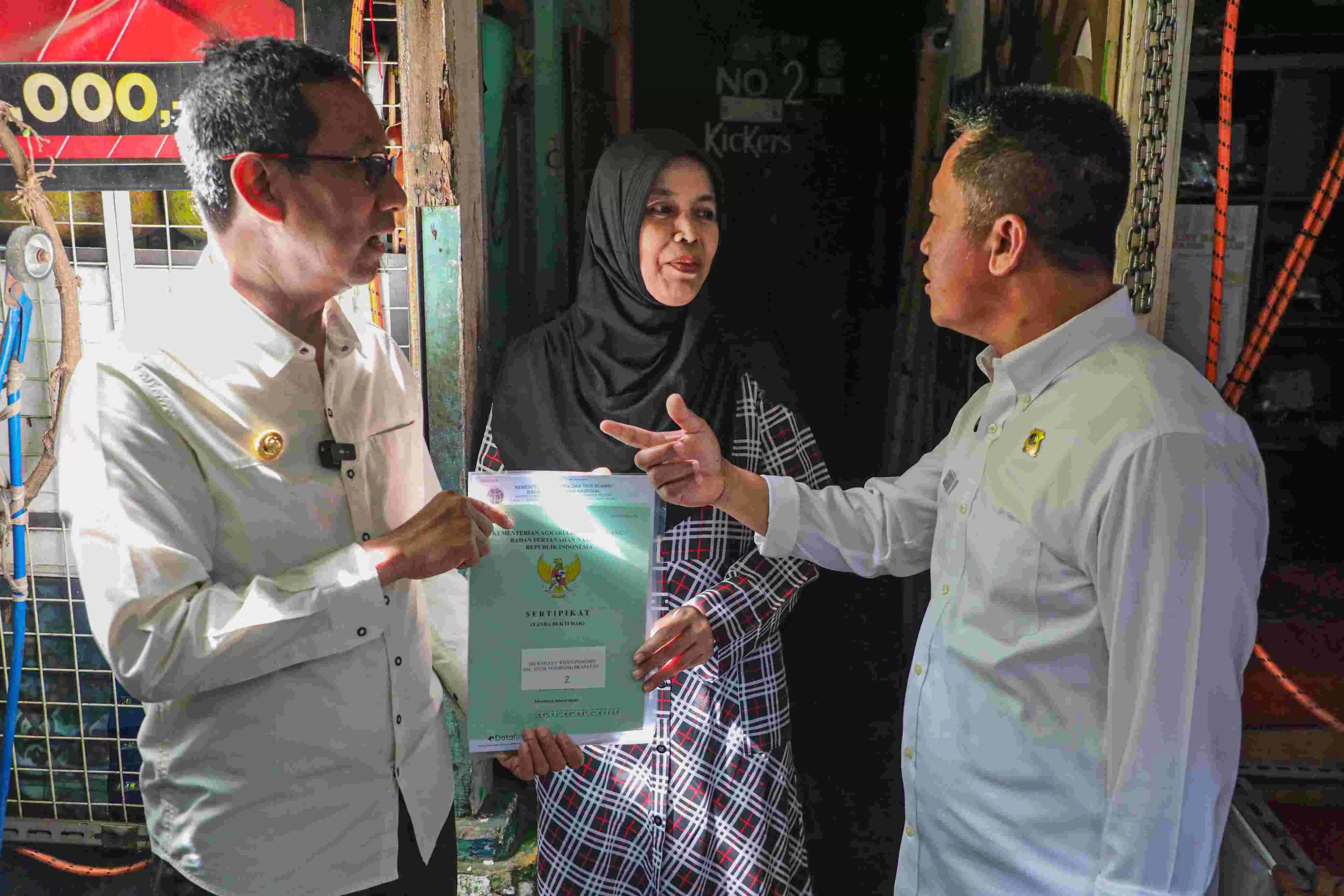 Penjabat (Pj.) Gubernur DKI Jakarta Heru Budi Hartono menyerahkan sertifikat tanah kepada warga di kelurahan Mampang Prapatan, Jakarta Selatan, Rabu (24/1/2024). Foto: Pemprov DKI