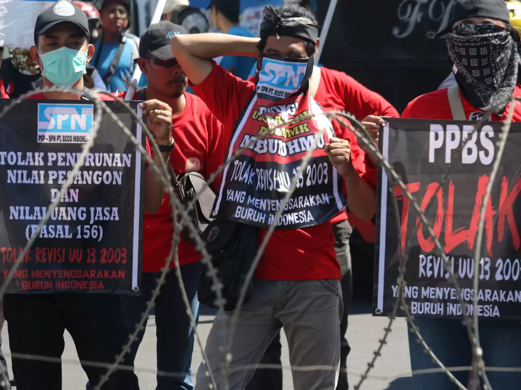 Sejumlah buruh berunjukrasa di depan Kantor Gubernur Jawa Timur di Surabaya, Jawa Timur, Kamis (18/7/2019). Mereka menolak revisi Undang Undang Nomor 13 Tahun 2003 tentang ketenagakerjaan. ANTARA FOTO/Didik Suhartono