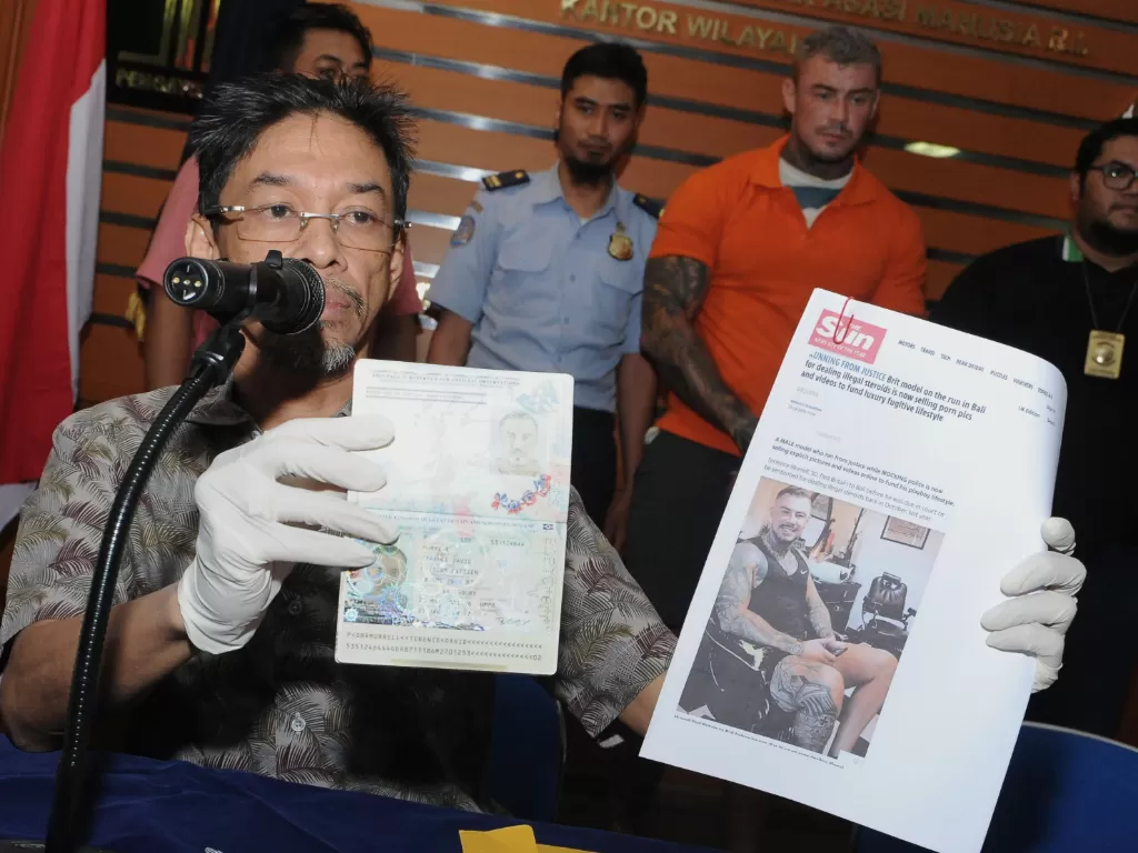 Petugas menunjukkan paspor milik Warga Negara Inggris berinisial TDM (kedua kanan) saat rilis di Kantor Imigrasi Kelas I Khusus Ngurah Rai, Badung, Bali, Selasa (30/7/2019). (ANTARA FOTO/Fikri Yusuf)
