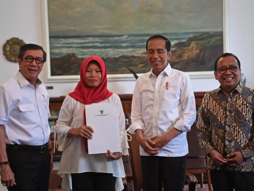 Baiq Nuril menerima salinan Keppres Amnesti yang sudah ditandatangani Presiden Jokowi di Istana Bogor, Jumat (2/8/2019). (ANTARA FOTO/Wahyu Putro A)