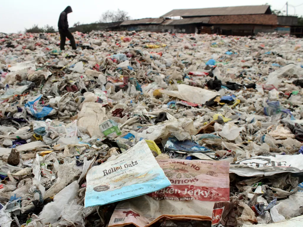 Warga melintas di atas tumpukan sampah plastik impor di Tempat Pembuangan Akhir (TPA) Burangkeng, Kabupaten Bekasi, Jawa Barat, Jumat (982019). (ANTARARisky Andrianto).