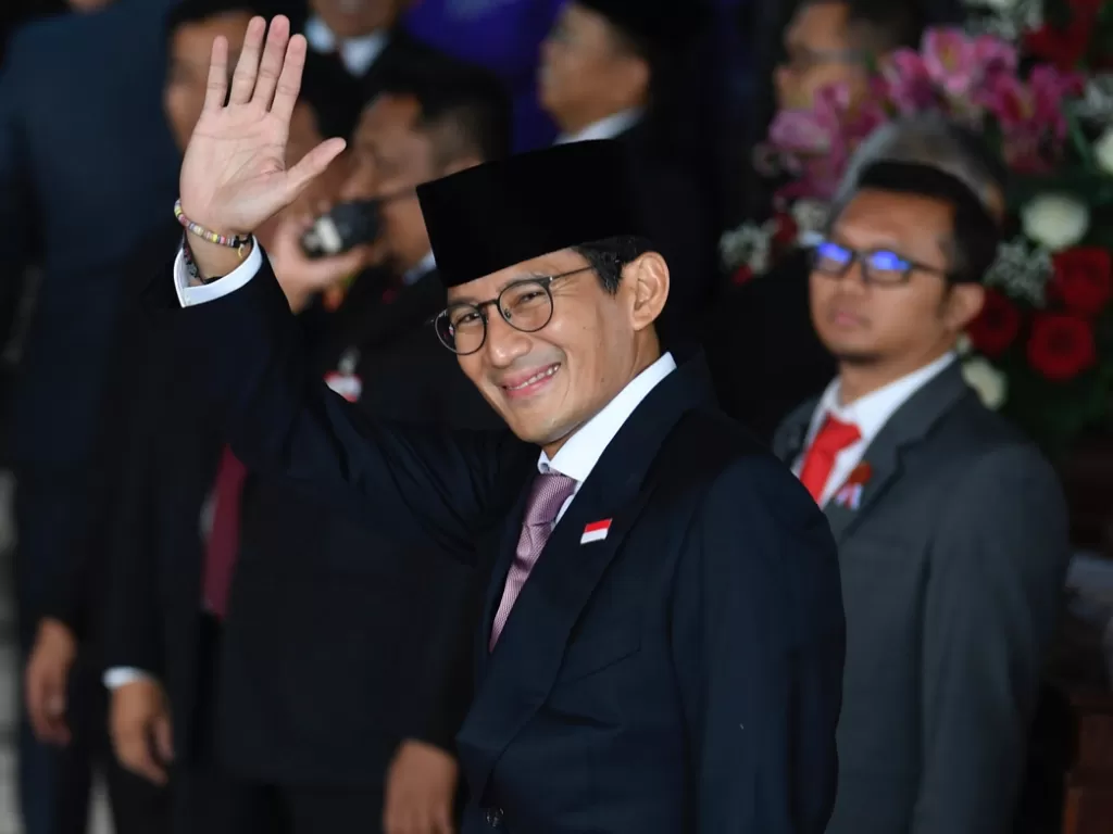 Sandiaga Uno melambaikan tangan saat tiba di Ruang Rapat Paripurna, Kompleks Parlemen, Jakarta, Jumat (16/8/2019). (ANTARA/Puspa Perwitasari).