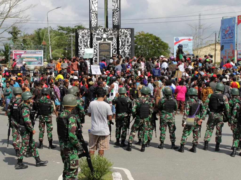 Warga melakukan aksi dengan pengawalan prajurut TNI di Bundaran Timika Indah, Mimika, Papua, Rabu (21/8/2019). (ANTARA/Jeremias Rahadat).