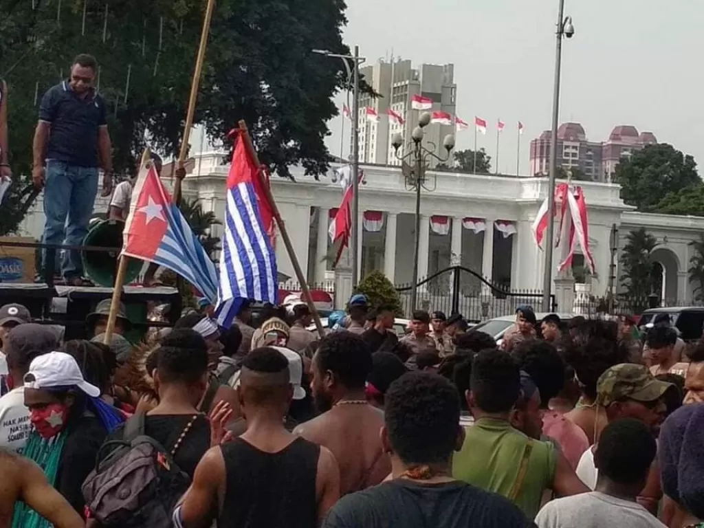 Massa unjuk rasa menentang rasisme di depan Istana Negara dengan mengibarkan bendera Bintang Kejora. (Sinteldam)