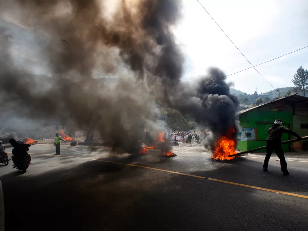 Sejumlah warga melakukan aksi tolak penggusuran Kampung Naringgul dengan membakar ban di Jalan Raya Puncak. (Antara/Yulius Satria Wijaya)