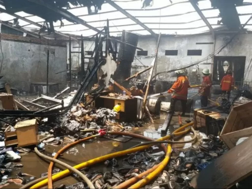 Petugas pemadam kebakaran melakukan pendingan di gudang pabrik sepatu. (Kasudin PKP Jakarta Utara dan Kepulauan Seribu)