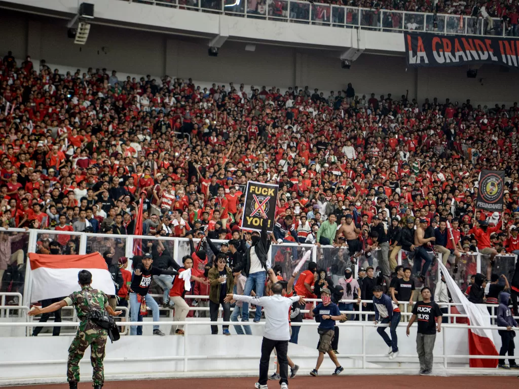Sejumlah suporter melompati pagar pembatas saat pertandingan Timnas Indonesia melawan Malaysia di Stadion Utama Gelora Bung Karno, Senayan, Jakarta, Kamis (5/9). (Antara/Hafidz Mubarak A).