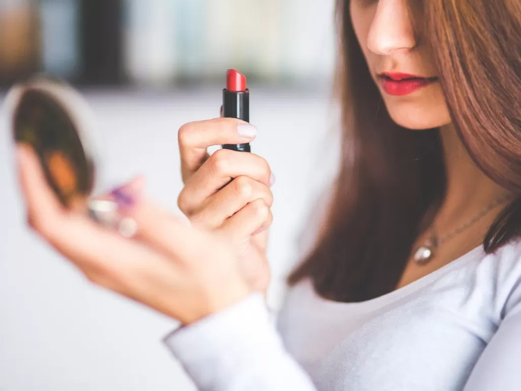Ilustrasi seorang wanita yang sedang memakai lipstik. (Visual hunt)