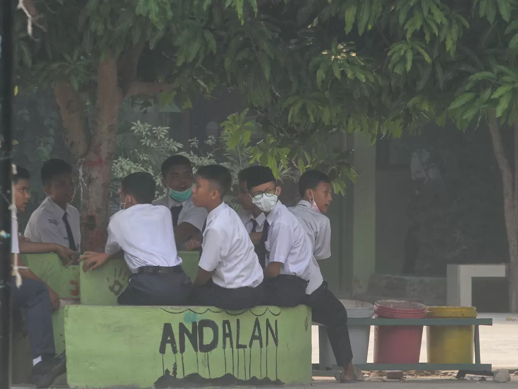 Siswa Madrasah Tsanawiyah Negeri 1 Pekanbaru dipulangkan lebih awal karena kualitas udara kembali memburuk akibat kabut asap. (Antara/Rony Muharrman)