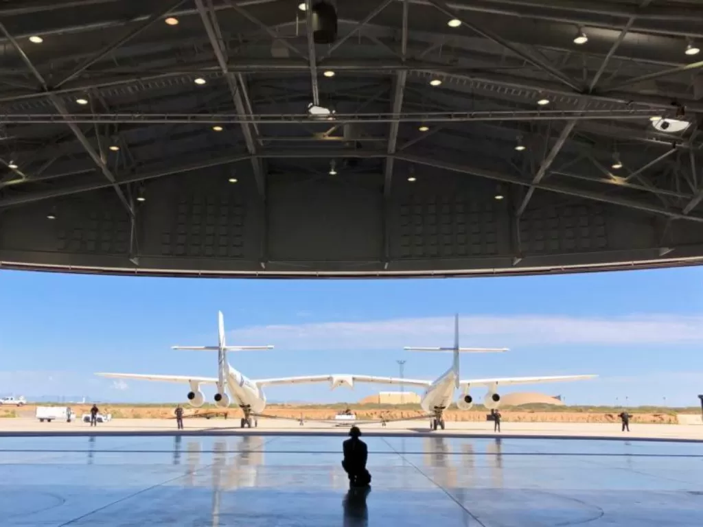 Kru darat Virgin Galactic memandu pesawat masuk ke hangar bandar antariksa Spaceport America setelah uji coba terbang dekat Upham, New Mexico. (AP via VOA)