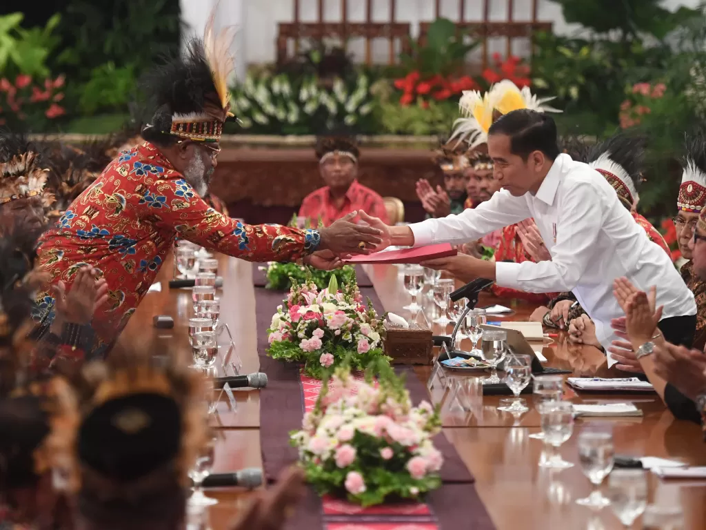 Presiden Jokowi menerima map berisi saran dari perwakilan tokoh Papua Abisai Rollo (kiri) dalam pertemuan di Istana Negara, Jakarta, Selasa (10/9). (Antara/Akbar Nugroho Gumay).