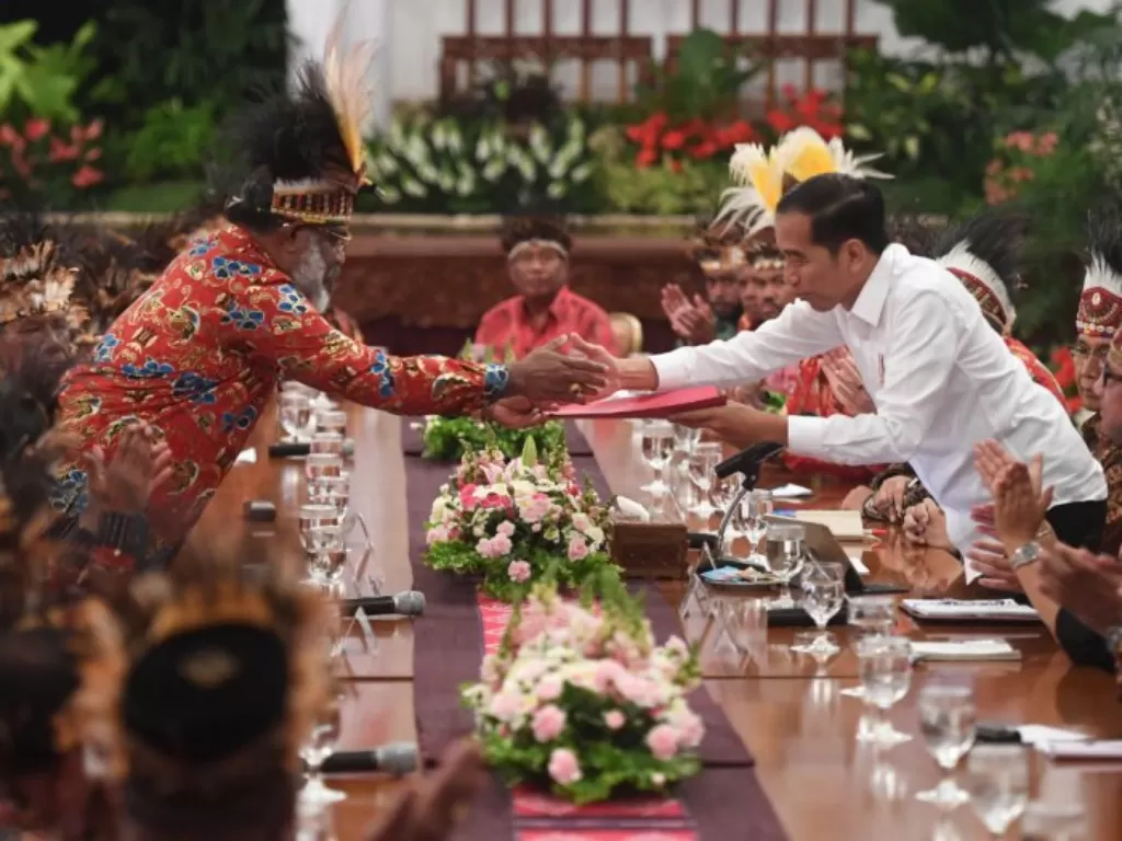  Presiden Jokowi menerima map berisi saran dari perwakilan tokoh Papua Abisai Rollo (kiri) dalam pertemuan di Istana Negara, Jakarta, Selasa (10/9). (Antara/Akbar Nugroho Gumay).