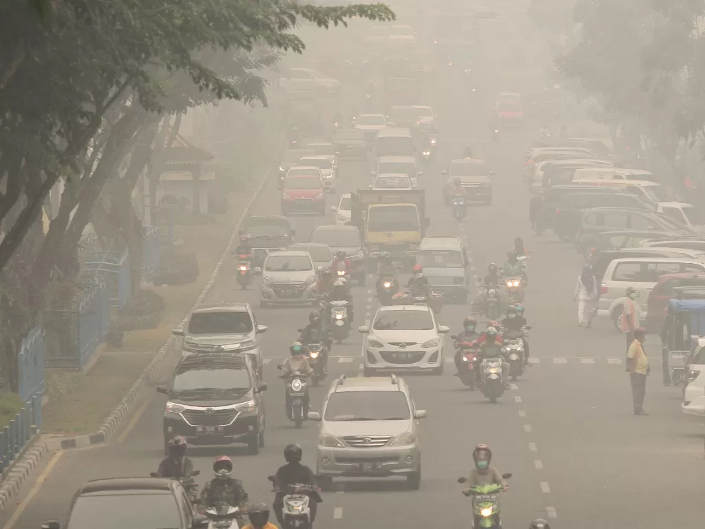 Pengendara kendaraan bermotor menembus kabut asap pekat di Pekanbaru, Riau. (Antara/Rony Muharrman)