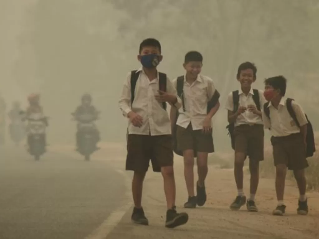 Ilustrasi anak-anak bersekolah di tengah kabut asap kebakaran hutan dan lahan. (ANTARA FOTO/Wahdi Septiawan)