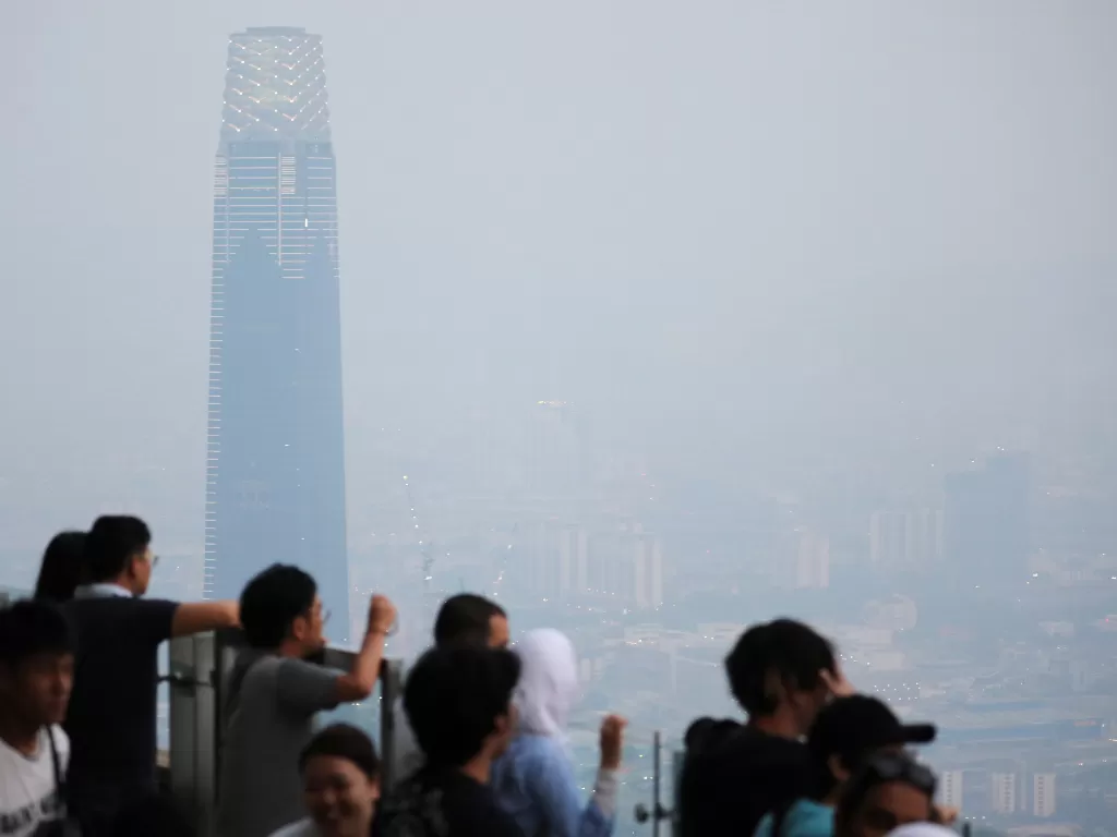 Wisatawan melihat cakrawala kota yang diselimuti kabut asap di Menara Kuala Lumpur. (Reuters/Lim Huey Teng)