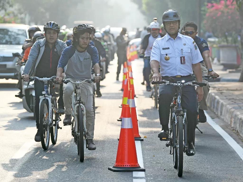 Gubernur DKI Jakarta Anies Baswedan (kanan) berbincang dengan warga ketika bersepeda di Jakarta, Jumat (20/9). (Antara/M Risyal Hidayat).