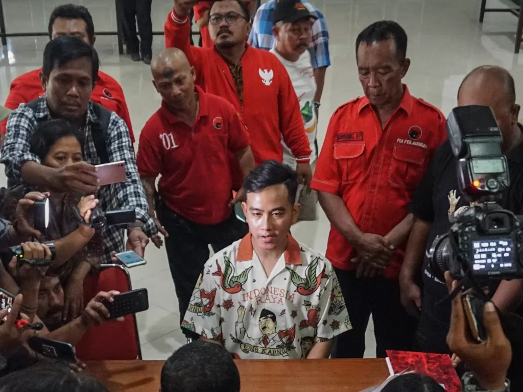 Putra sulung Presiden Joko Widodo, Gibran Rakabuming Raka (tengah) menyerahkan berkas pendaftaran anggota PDIP, Senin (23/9). (Antara/Mohammad Ayudha).