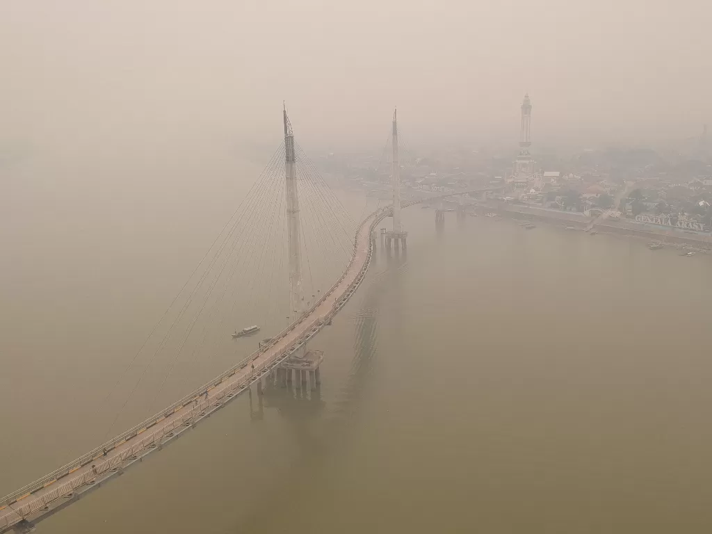 Foto udara Sungai Batanghari yang diselimuti kabut asap dari karhutla di Jambi, Sabtu (21/9). (Antara/Wahdi Septiawan).