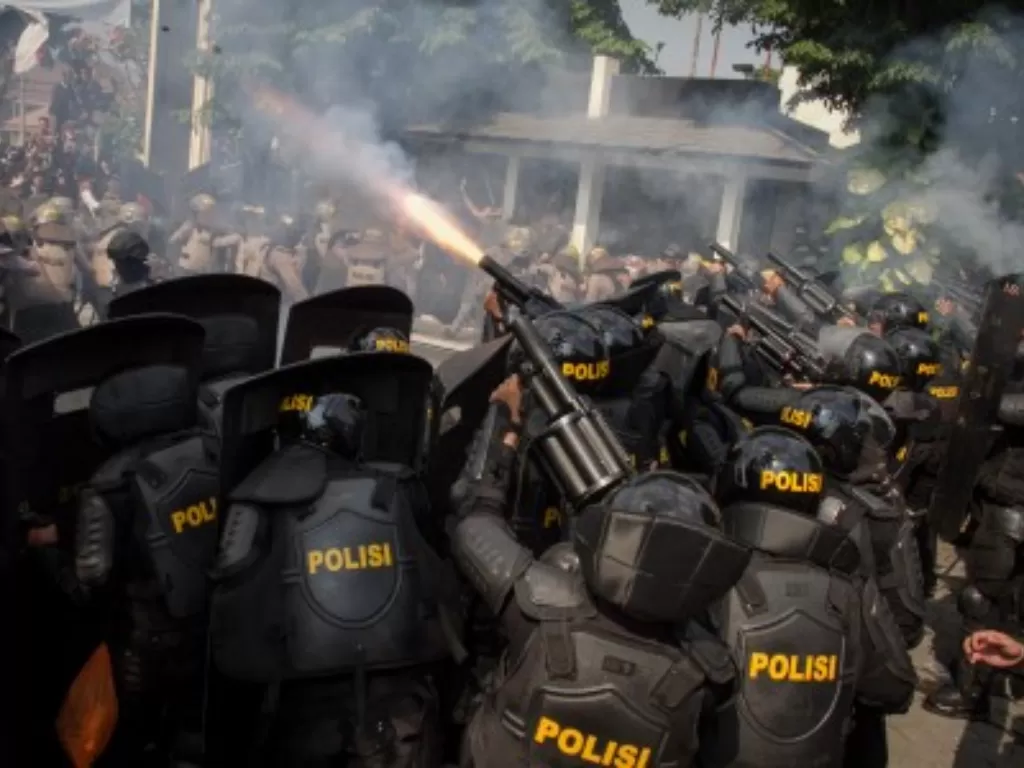Aparat Kepolisian menembakkan gas air mata untuk menghalau mahasiswa yang memaksa masuk ke kantor Dewan Perwakilan Rakyat Daerah (DPRD) saat aksi unjuk rasa di kantor DPRD Solo, Jawa Tengah. (Antara/Mohammad Ayudha)