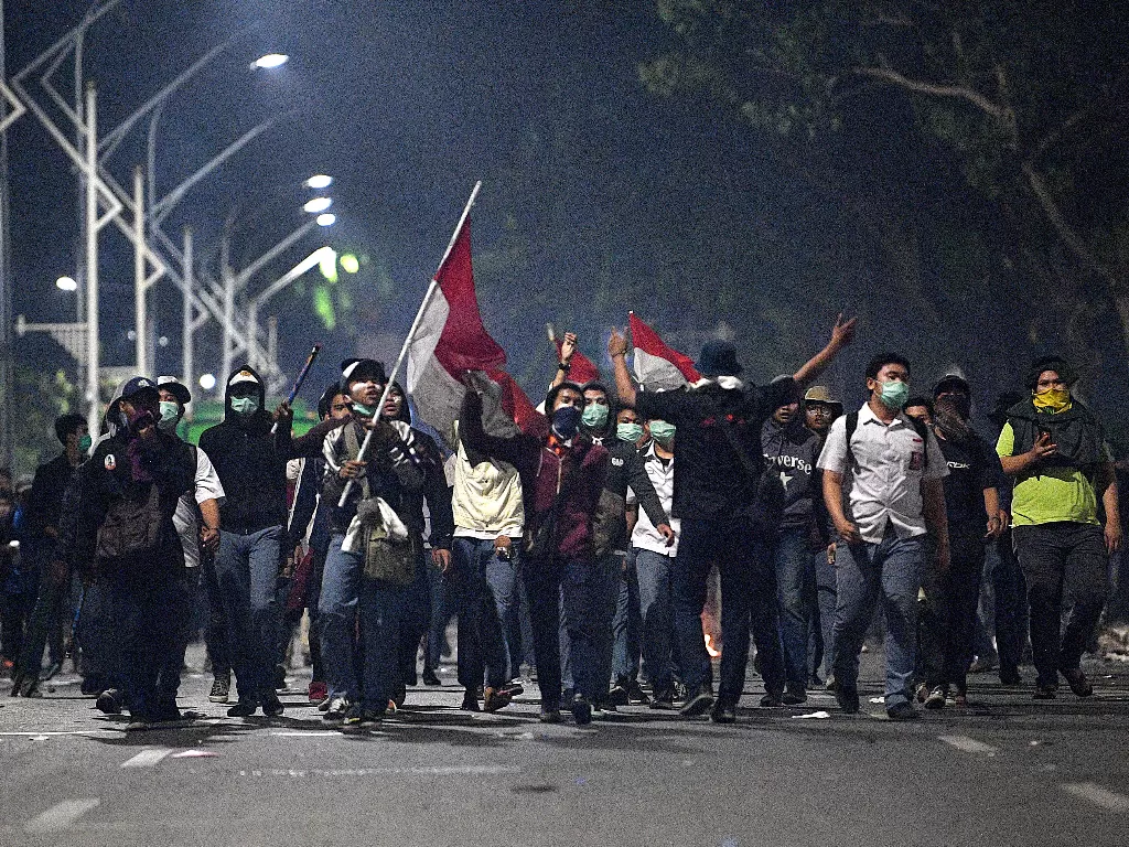 Sejumlah pelajar mengikuti unjuk rasa di Jalan Gerbang Pemuda, Senayan, Jakarta, Selasa (24/9) malam. Aksi menuntut pembatalan RKUHP itu berujung ricuh (Antara/Sigid Kurniawan).