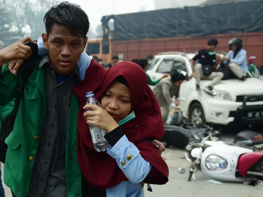 Mahasiswa yang tergabung dalam Aliansi Sumsel Melawan menyelamatkan diri saat terlibat bentrok dengan aparat keamanan di luar gedung DPRD Sumatera Selatan, Palembang, Sumatera Selatan, Selasa (24/9). (Antara/Mushaful Imam)