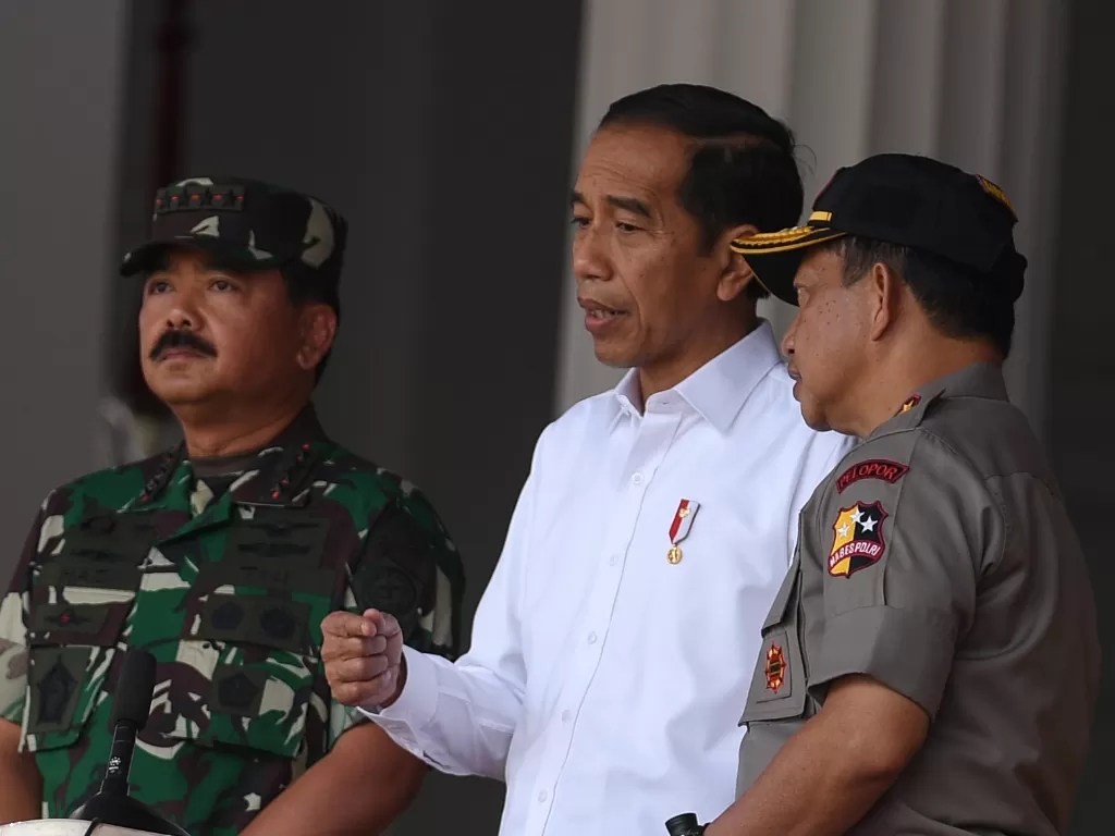 Presiden Joko Widodo (tengah) didampingi Panglima TNI Marsekal TNI Hadi Tjahjanto (kiri) dan Kapolri Jenderal Pol Tito Karnavian. (Antara/Wahyu Putro A)