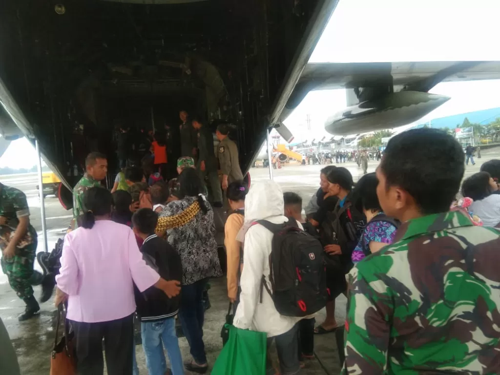Pengungsi di Lanud Silas Papare menaiki Hercules milik TNI untuk kembali ke Wamena. (Kemenkopolhukam)