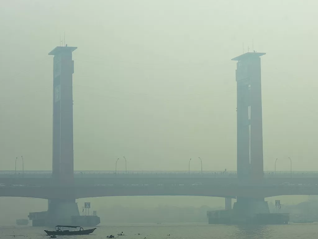 Warga beraktivitas di perairan Sungai Musi yang tertutup kabut asap di Palembang, Sumatera Selatan, Jumat (11/10). (Antara/Mushaful Imam).