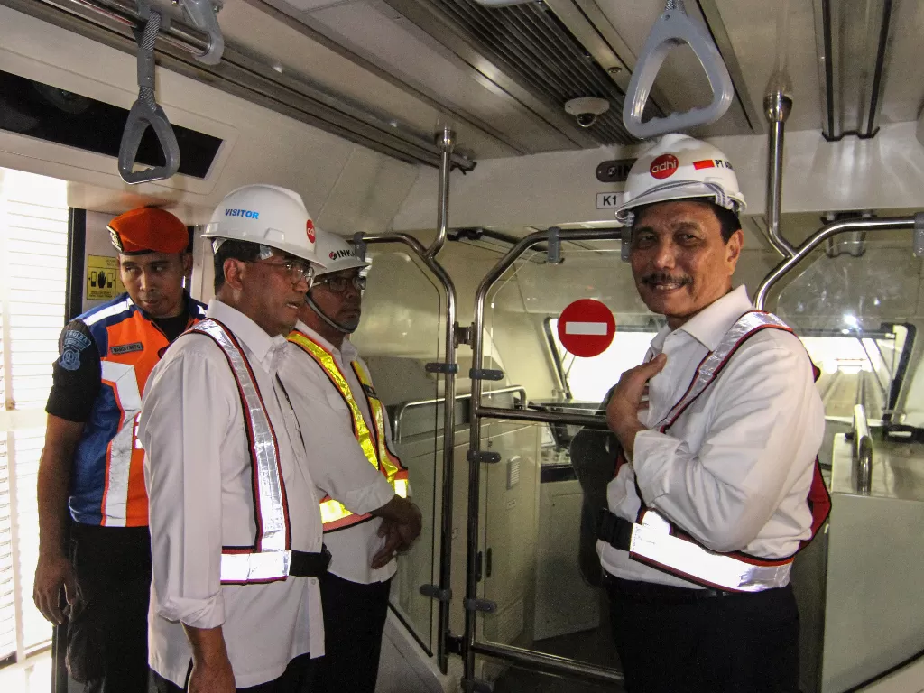 Menko Maritim Luhut Binsar Panjaitan (kanan) dan Menhub Budi Karya Sumadi (kedua kiri) meninjau kondisi bagian dalam gerbong  LRT usai diangkat secara perdana di Stasiun Harjamukti, Depok, Jawa Barat. (Antara/Asprilla Dwi Adha)