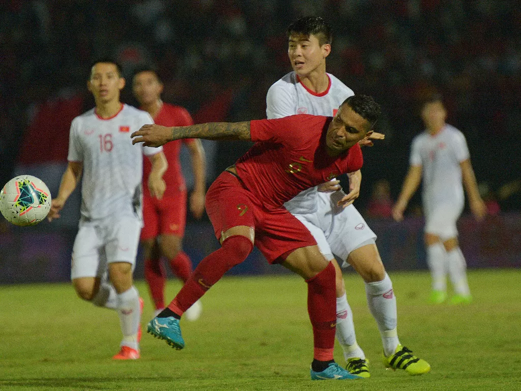 Alberto Goncalves (depan) berebut bola dengan pesepak bola Timnas Vietnam Do Duy Manh (kedua kanan) dalam pertandingan itu Timnas Indonesia kalah dengan skor 1-3. (Antara Foto/Nyoman Budhiana)